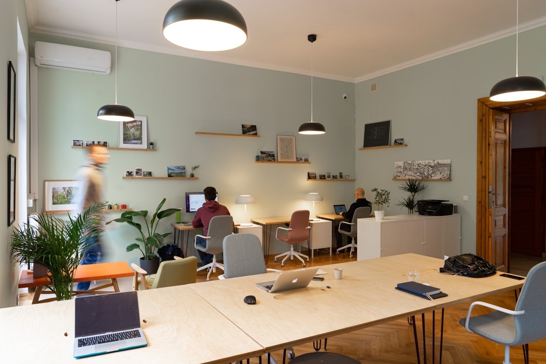 Three people working at desks in a modern coworking office.